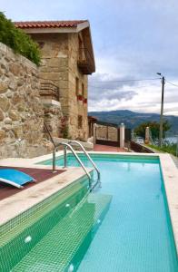 a swimming pool in front of a house at Pedacinho de Mundo Douro in Passinhos de Cima