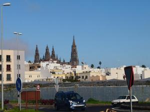 Casa Aridani في أروكاس: a car driving down a street with a city in the background