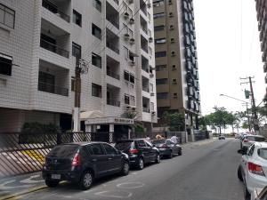 uma fila de carros estacionados em frente a um edifício em ACONCHEGO SANTOS em Santos