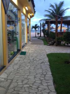 a walkway in front of a building with palm trees at Pousada Funny in Morro de São Paulo