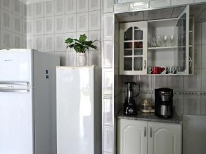 a kitchen with a white refrigerator and a cabinet at Bertioga-Costa do Sol MK9 in Praia Guaratuba