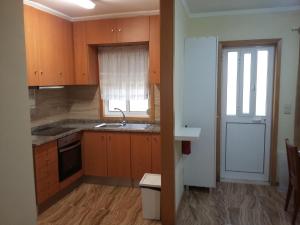 a kitchen with wooden cabinets and a sink and a window at Al Gaia Centro Historico in Vila Nova de Gaia