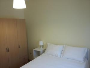 una camera da letto con un letto con lenzuola bianche e una lampada di Al Gaia Centro Historico a Vila Nova de Gaia
