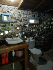 a bathroom with a toilet and a sink at Apartments Chez Milady in Utila