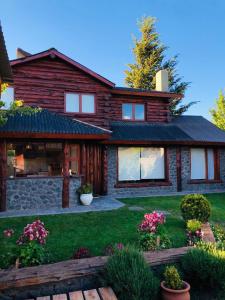 a log house with a garden in front of it at Cabañas Temistocles in Esquel