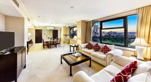 a living room with couches and a large window at The Sydney Boulevard Hotel in Sydney