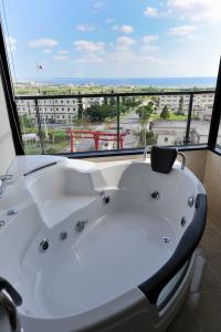 a bath tub in a room with a large window at Royal Hotel in Yomitan