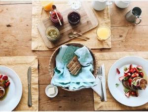 a wooden table with plates of food and a plate of food at Gîte Aux Jardins De L'Anse in Perce +23 photos