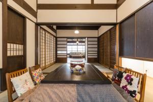 uma sala de jantar com uma grande mesa e cadeiras em 京町家一棟貸しKyoto Machiya Stay En em Quioto