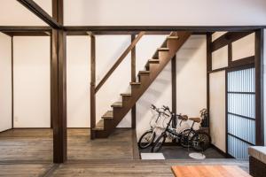 a room with a staircase and a bike on the wall at 京町家一棟貸しKyoto Machiya Stay En in Kyoto