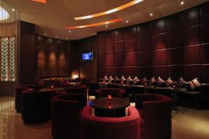 a waiting room with red chairs and a tv at Taj Coromandel in Chennai