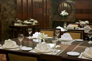 a dining room with a table with glasses and napkins at Taj Coromandel in Chennai