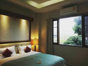 ein Schlafzimmer mit einem Bett und einem großen Fenster in der Unterkunft Green Hill Resort Phurue in Phu Rua