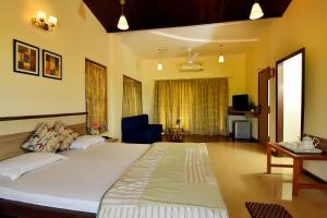 ein Schlafzimmer mit einem großen Bett in einem Zimmer in der Unterkunft The Mango Inn in Dapoli