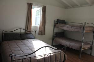 1 dormitorio con 2 literas y ventana en Riverside Haven Lodge & Holiday Park, en Waianakarua