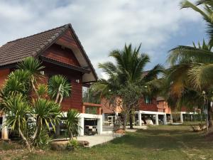 ein Haus mit Palmen davor in der Unterkunft Green Hill Resort Phurue in Phu Rua