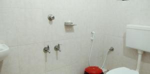 a white bathroom with a toilet and a sink at Madaparambil Tenants Home in Ernakulam