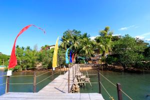 a wooden dock with flags and tables on the water at Discovery Island Resort in Coron