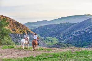 two people riding horses in the mountains at Circle Bar B Guest Ranch in Santa Barbara