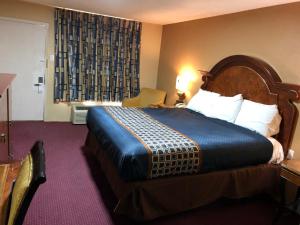 a hotel room with a large bed and a window at Villa West Inn in Odessa