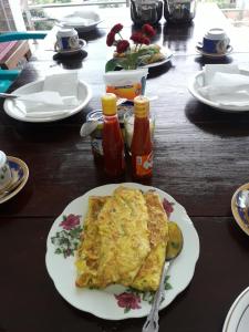 a table with a plate of omelet on a table at Toraja Lodge Hotel in Rantepao