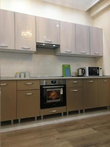 a kitchen with white cabinets and a stove top oven at TRILLIONER Apartment 885 in Aktau