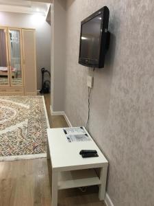 a room with a tv on a wall with a table at TRILLIONER Apartment 885 in Aktau