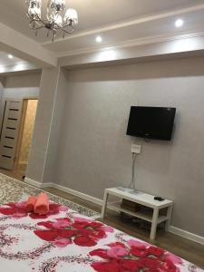 a living room with a bed and a flat screen tv at TRILLIONER Apartment 885 in Aktau