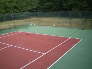 a tennis court with a net on top of it at les bois de saint auvent in La Geneytouse