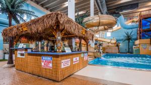 a swimming pool with a drink bar and a water slide at Seven Oaks Hotel Regina in Regina