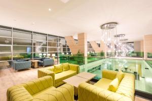 a lobby with yellow couches and a pool at Best Western Premier Batumi in Batumi