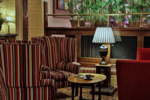 a living room with two chairs and a table with a lamp at The Bull Hotel; Sure Hotel Collection by Best Western in Peterborough