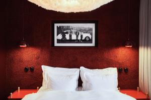 ein Schlafzimmer mit einem Bett und einem Bild an der Wand in der Unterkunft NOFO Hotel, WorldHotels Crafted in Stockholm