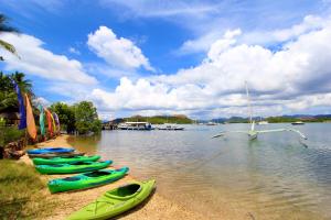 a row of kayaks on the shore of a lake at Discovery Island Resort in Coron