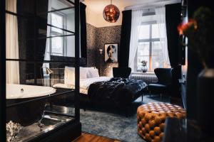 ein Schlafzimmer mit Bett und ein Badezimmer mit Waschbecken in der Unterkunft NOFO Hotel, WorldHotels Crafted in Stockholm