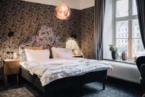 ein Schlafzimmer mit einem Bett und einer tapezierten Wand. in der Unterkunft NOFO Hotel, WorldHotels Crafted in Stockholm + 102 Fotos