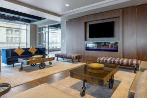 a living room with a couch and a tv at Cambria Hotel Downtown Asheville in Asheville