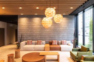 a lobby with a couch and chairs and lights at Tokyu Stay Sapporo Odori in Sapporo