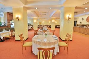 a dining room with tables and chairs in a restaurant at Grand Mir Hotel in Tashkent