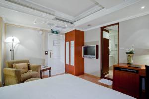 台北的住宿－太豪大飯店，酒店客房配有一张床、一把椅子和一台电视。
