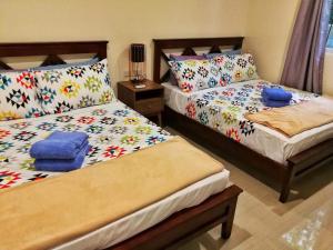 a bedroom with two beds with flowers on them at Panglao Paradise Homes in Panglao