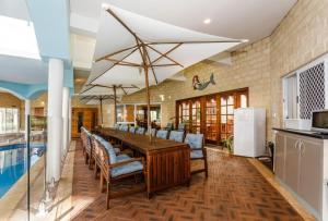 a dining room with a table and chairs and a pool at Inn The Tuarts Guest Lodge Busselton Accommodation - Adults Only in Busselton