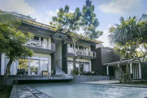 a house with a swimming pool in front of it at Kajane Tulamben Bali in Tulamben