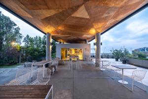 Un patio con mesas y sillas y un edificio. en Clove Hotel Bandung, en Bandung
