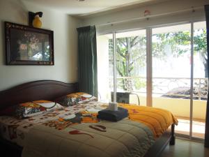 a bedroom with a bed and a large window at Nong Nuey Rooms in Ko Samed