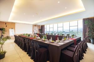 a long table with chairs in a room with windows at Clove Hotel Bandung in Bandung +55 photos
