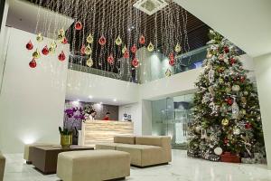 a christmas tree in a lobby with christmas decorations at Ramada Encore by Wyndham Makati in Manila