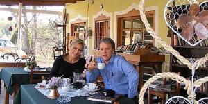 a man and a woman sitting at a table with a cup at The Pennefather in Haenertsburg