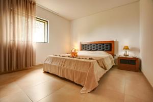 um quarto com uma cama grande e uma janela em Casa dos Limoeiros em Ribas em Celorico de Basto