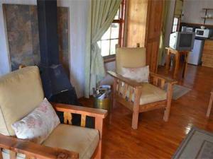 a living room with two chairs and a fireplace at The Pennefather in Haenertsburg